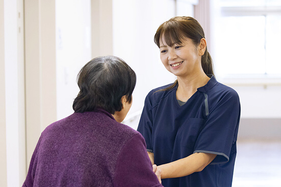 住宅型有料老人ホームの従業員が入居者様と会話している風景